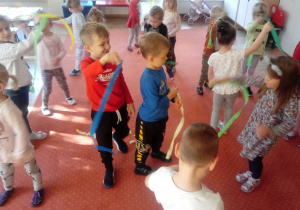 Dzieci tańczą z paskami kolorowej bibuły
